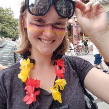 Mariah Ligas, scholarship recipient. Young woman with red, black and gold lei and facepaint.